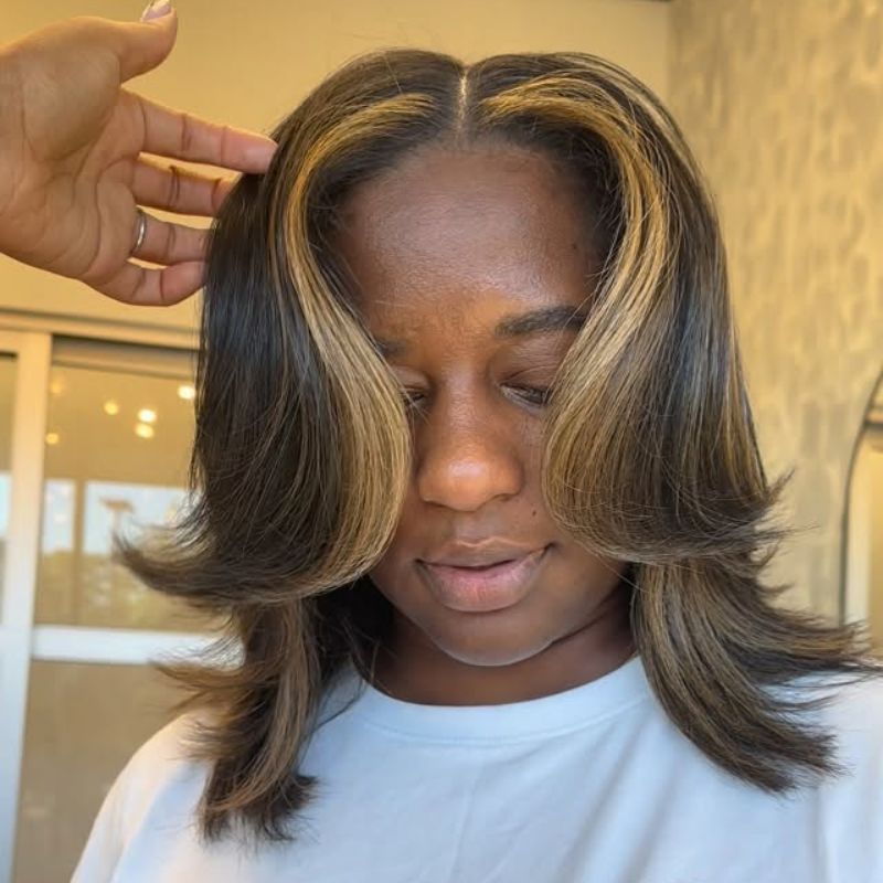 Dimensional blonde highlights blended into a dark base for a natural, transitional color result.