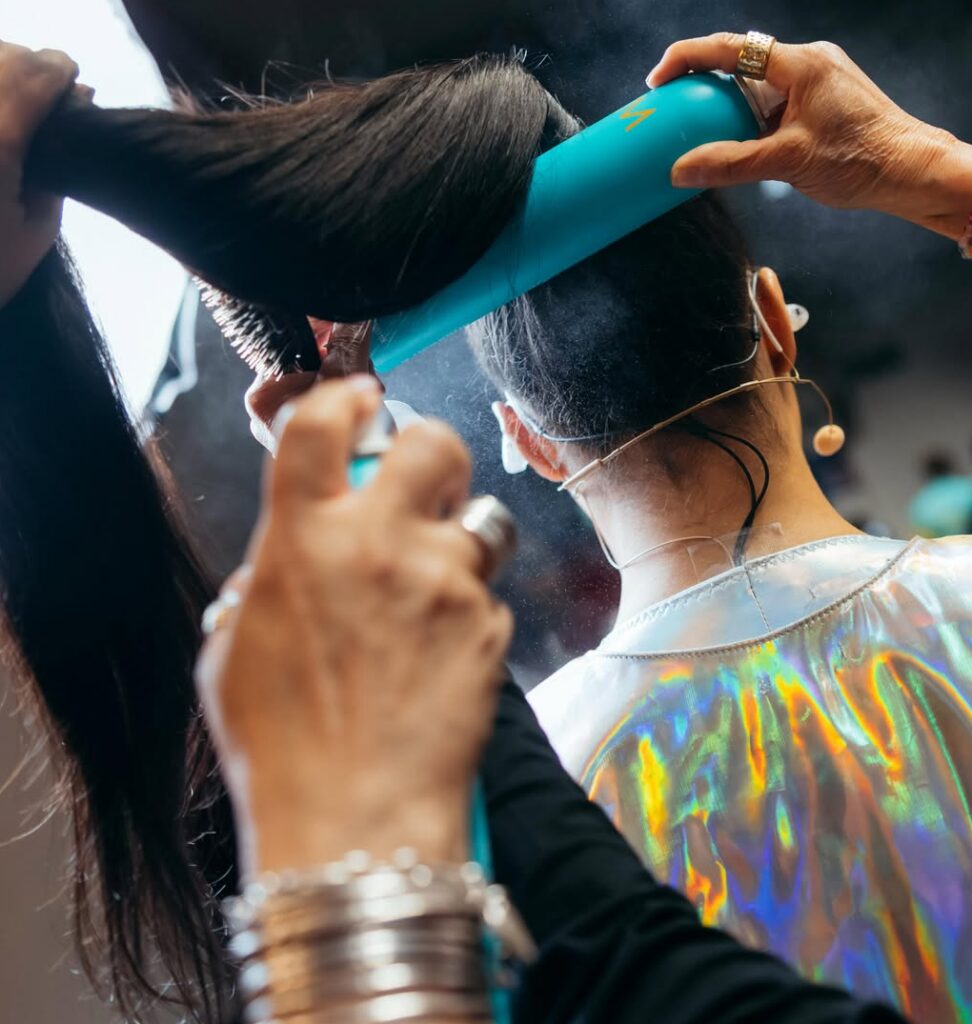 Hairspray being applied to ponytail with Moroccanoil product