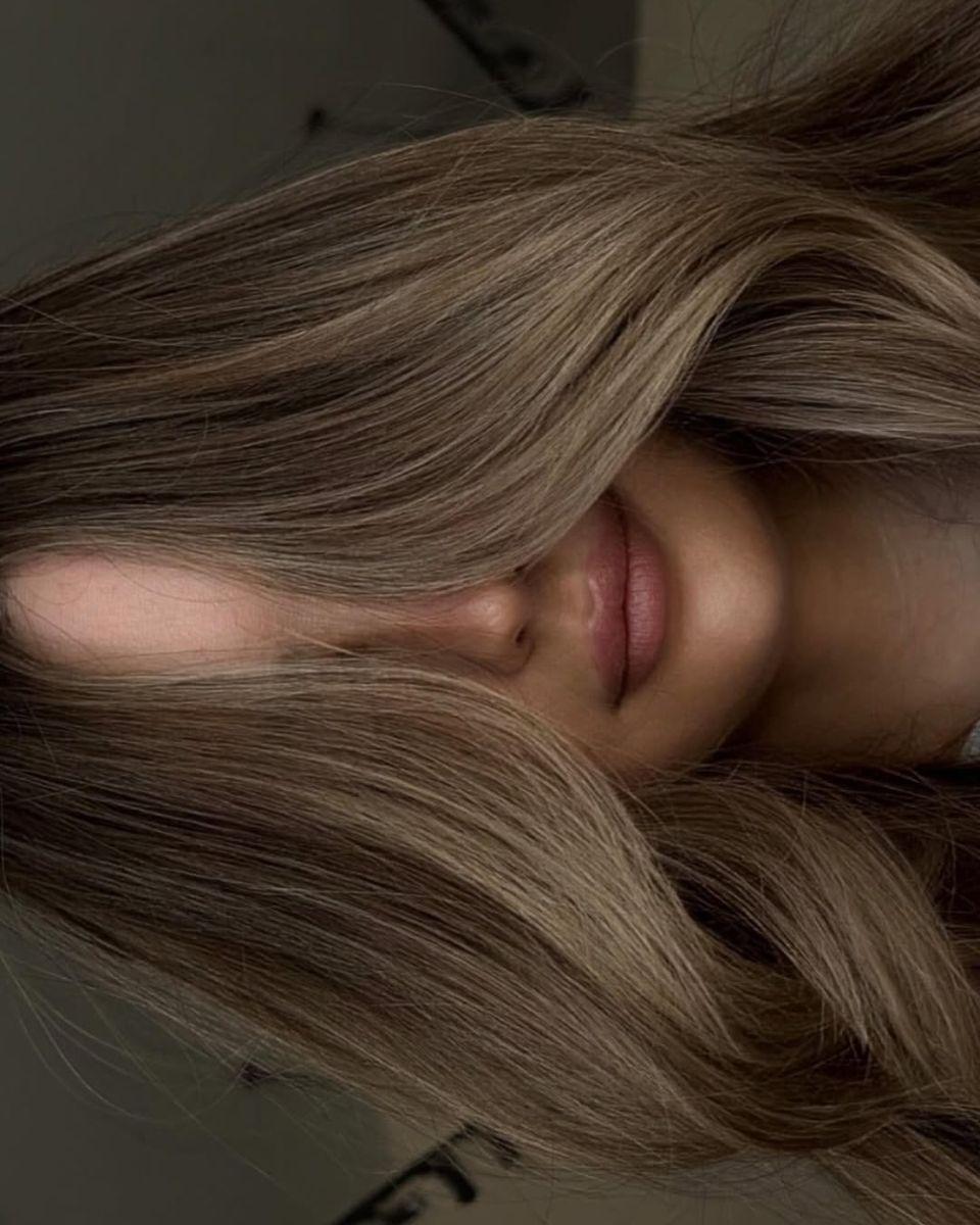 Close-up of blended bronde hair color showing beige-blonde ribbons, soft lowlights and dimensional waves.