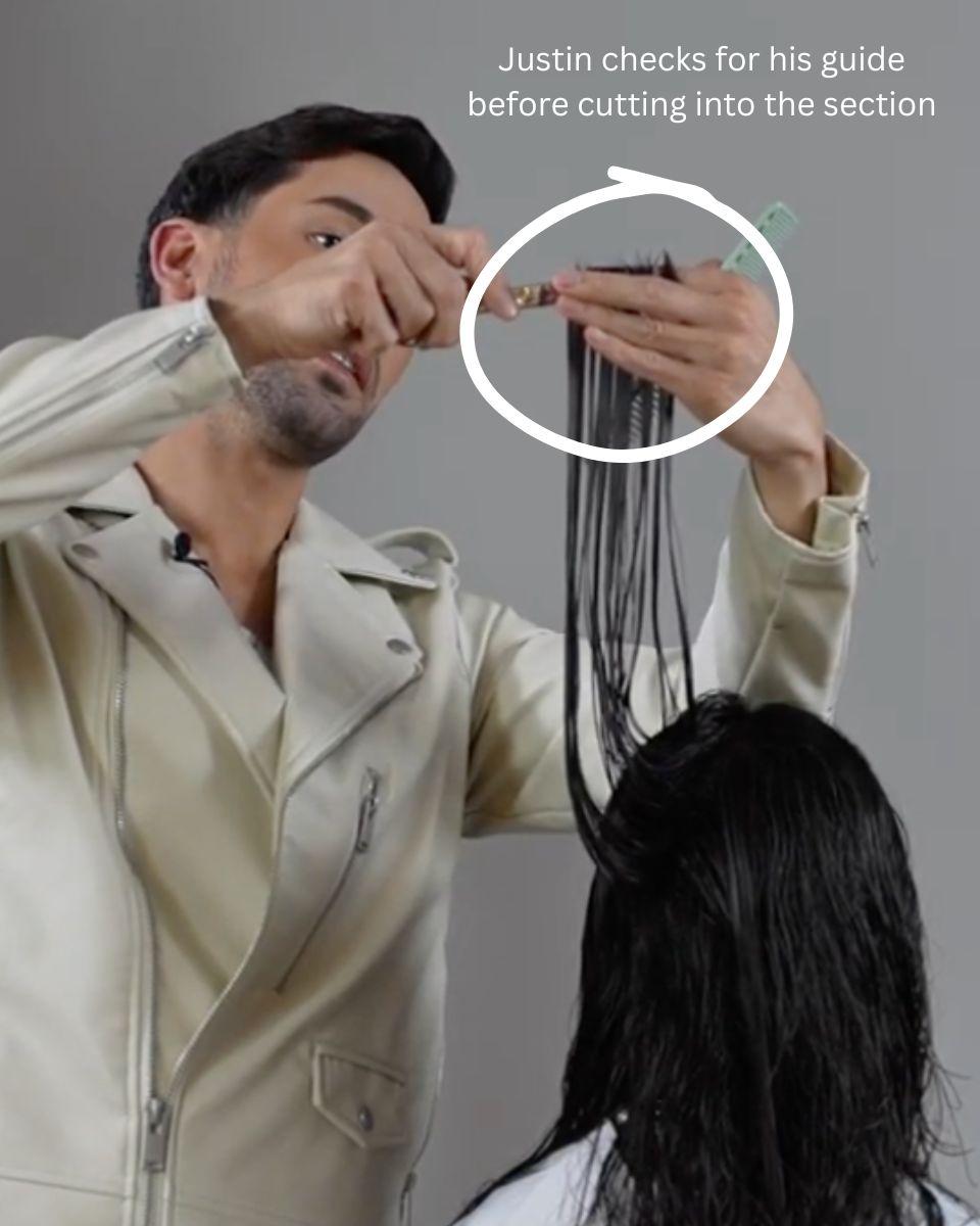 Stylist checks the guide before cutting into a vertical section to avoid creating holes in long layered hair.