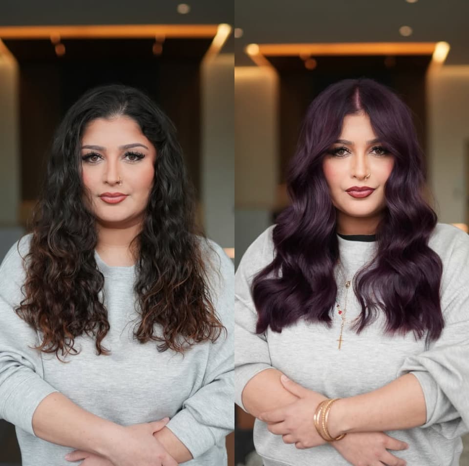 Before-and-after hair transformation showing a client’s dark, wavy brunette hair transformed into glossy, dimensional plum-purple waves.