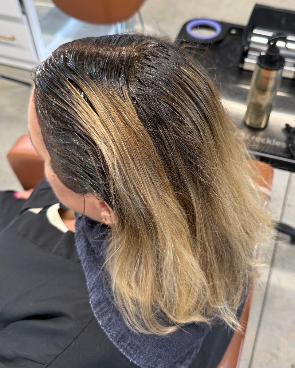 Overhead view of TRUSS Fast Color applied to a client’s gray regrowth, with blonde mids and ends left out.
