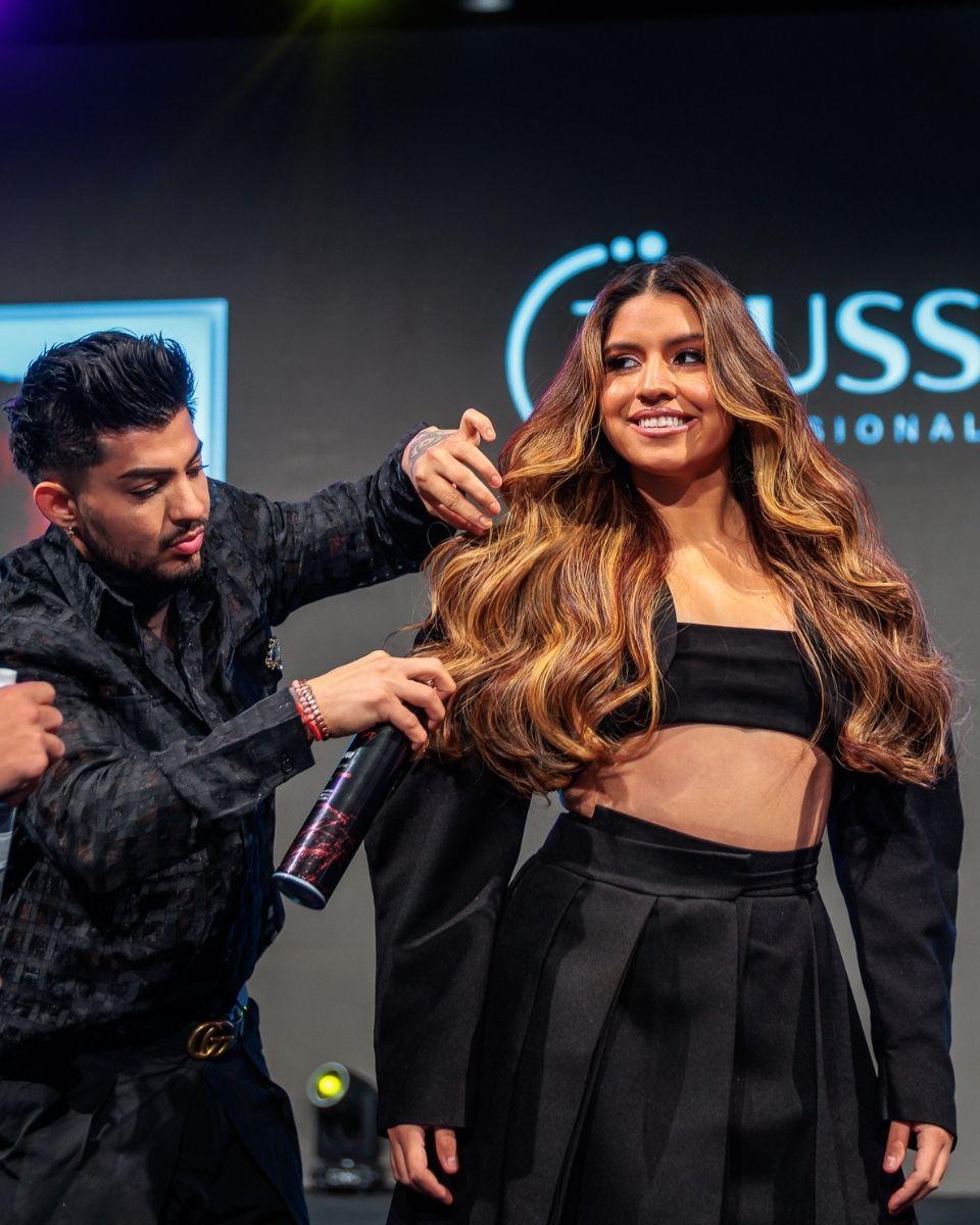 Jorge Ramirez assists onstage with a model’s long dimensional blonde hair during Gabriel Samra’s TRUSS Professional class.