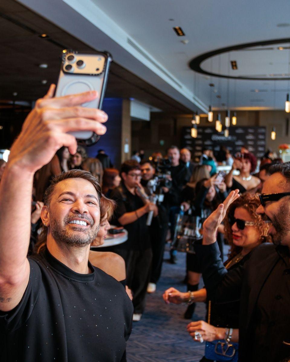 A TRUSS professional attendee takes a selfie with the bustling crowd.
