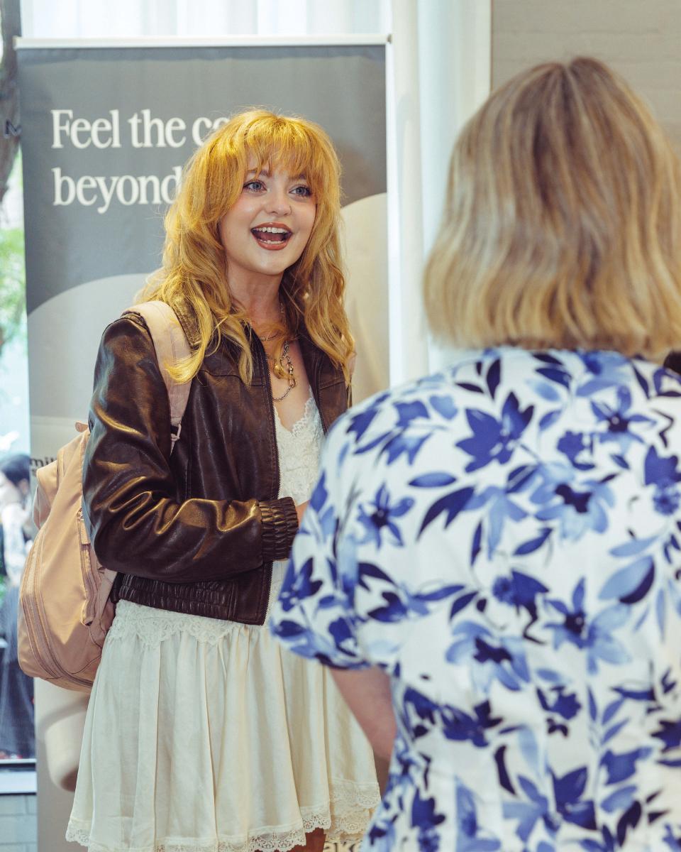 Lauren Freas speaks with Aubrey Schutté near the Everlasting Bonds event signage at Rob Peters Salon.