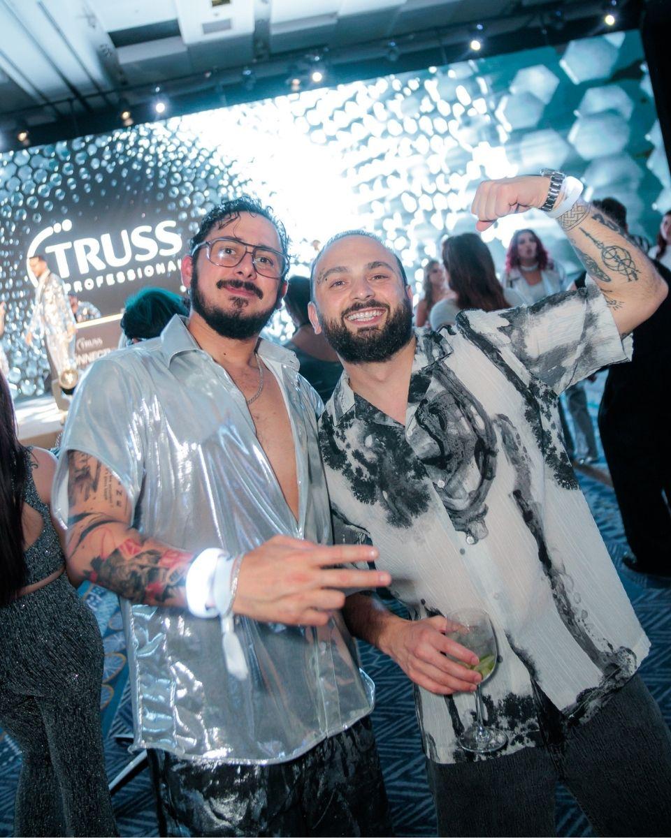 Two guests pose in metallic silver outfits during a TRUSS Professional event party.