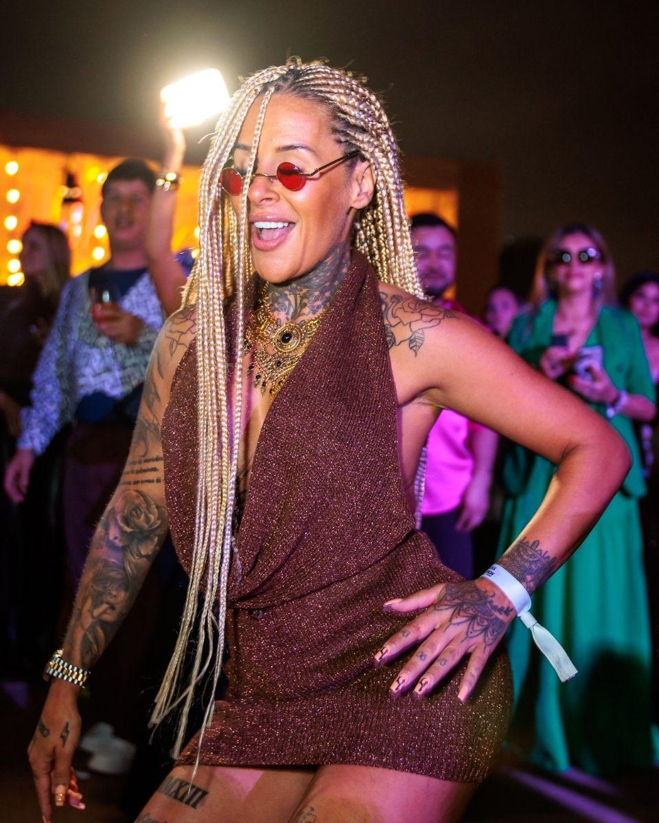 A guest dances in a brown dress and sunglasses during an outdoor evening celebration in Lima, Peru.