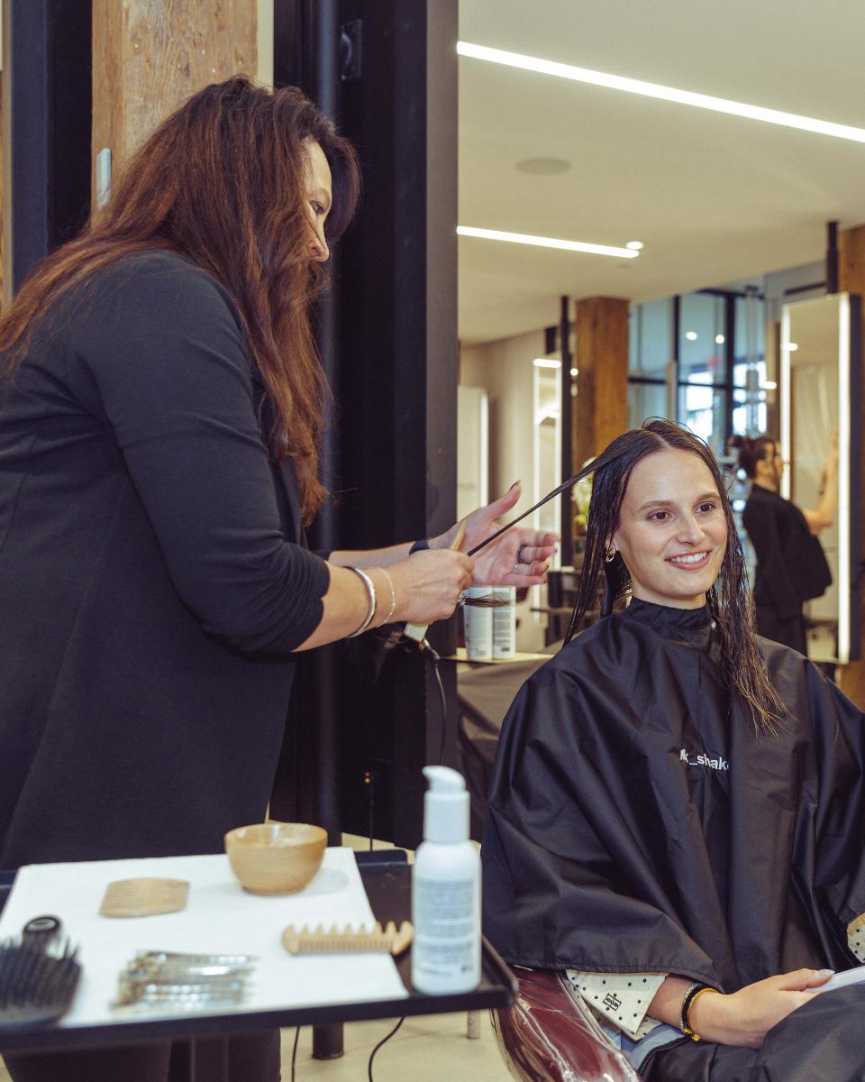 A milk_shake stylist applies Everlasting Bonds treatment to a guest’s wet hair at Rob Peters Salon.