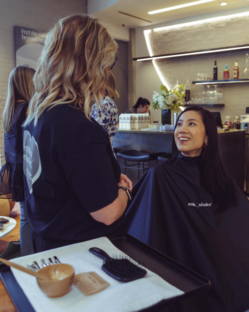 A milk_shake stylist speaks with a guest before her Everlasting Bonds service at Rob Peters Salon.