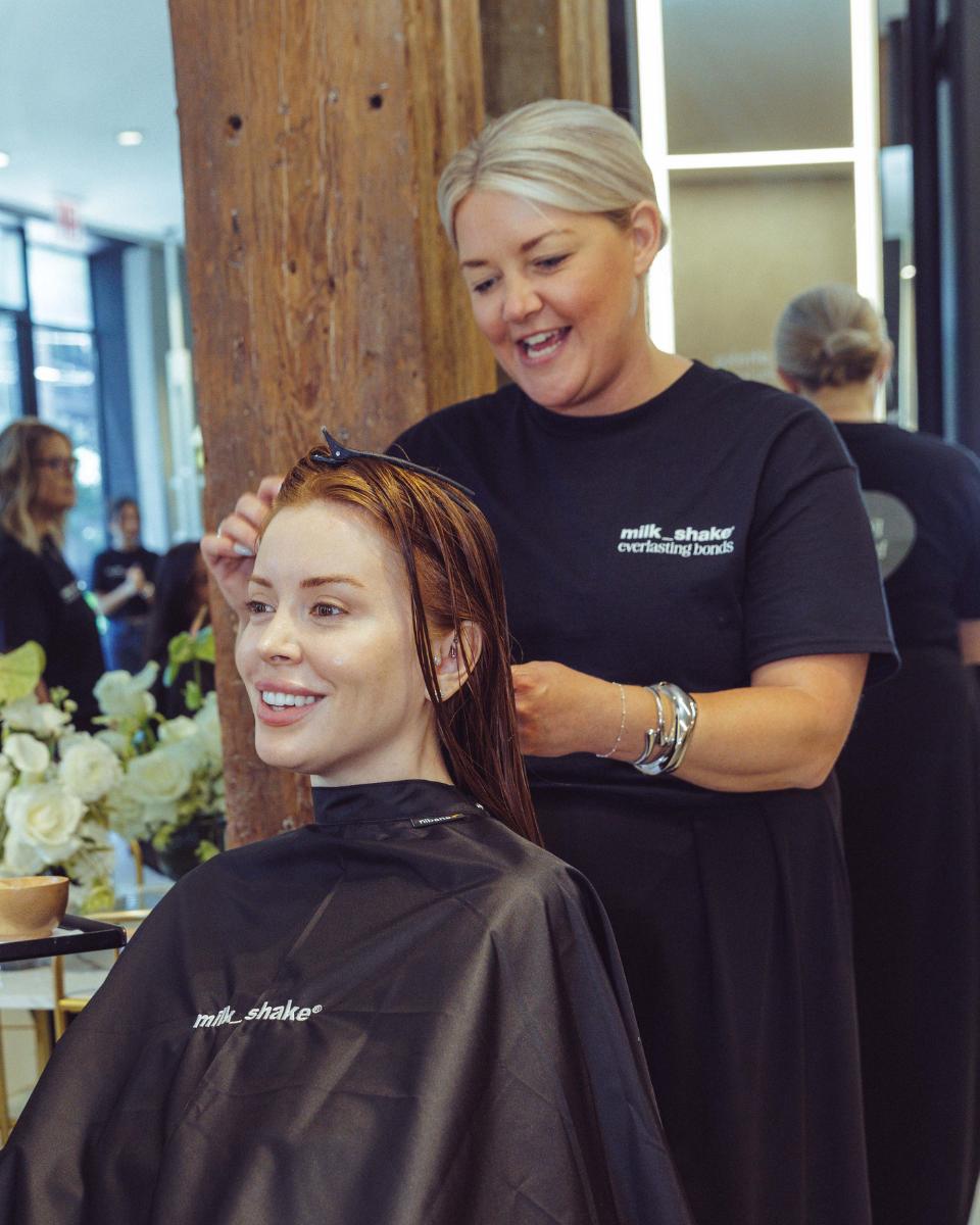 A milk_shake stylist sections a guest’s wet copper hair before applying the Everlasting Bonds treatment.