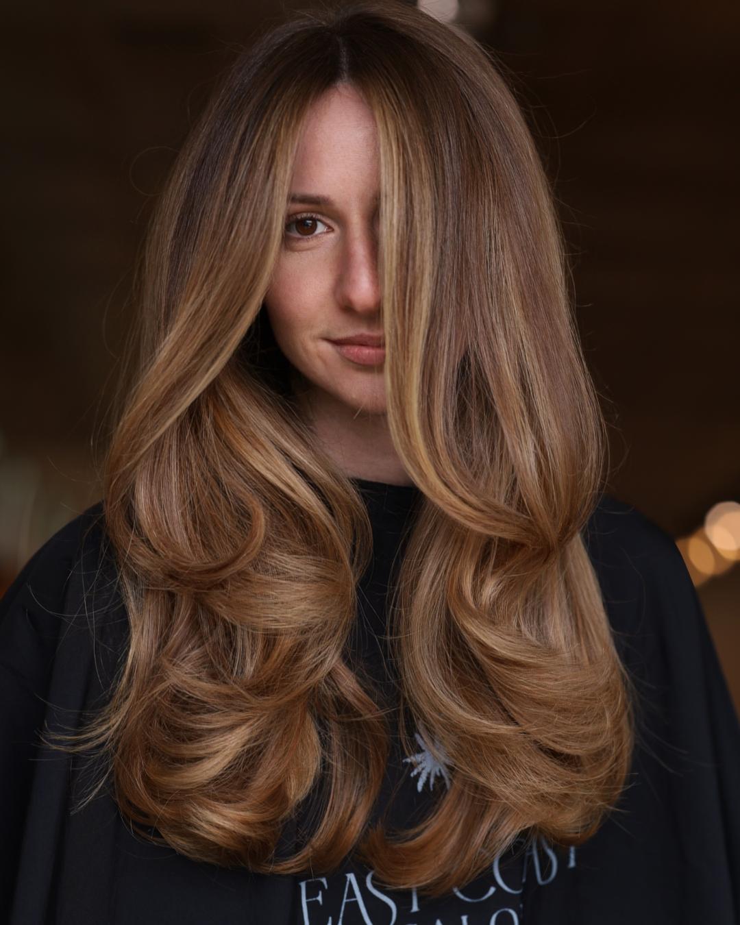 strawberry beige with bouncy layers and blowout Photo Credit Instagram via @sarayahhernandez