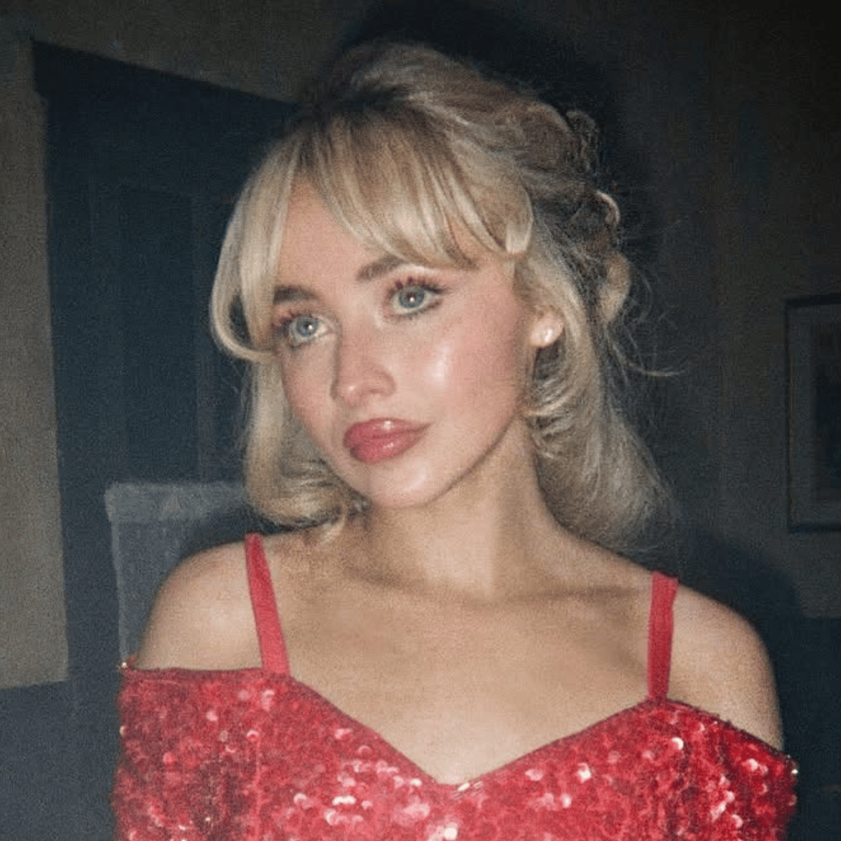Sabrina Carpenter with vintage-inspired buttery blonde updo and bangs in a red sequin dress from “Manchild.”