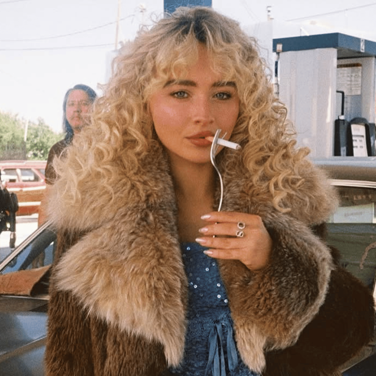 Sabrina Carpenter with airy, layered buttery blonde curls in the desert for the “Manchild” music video.