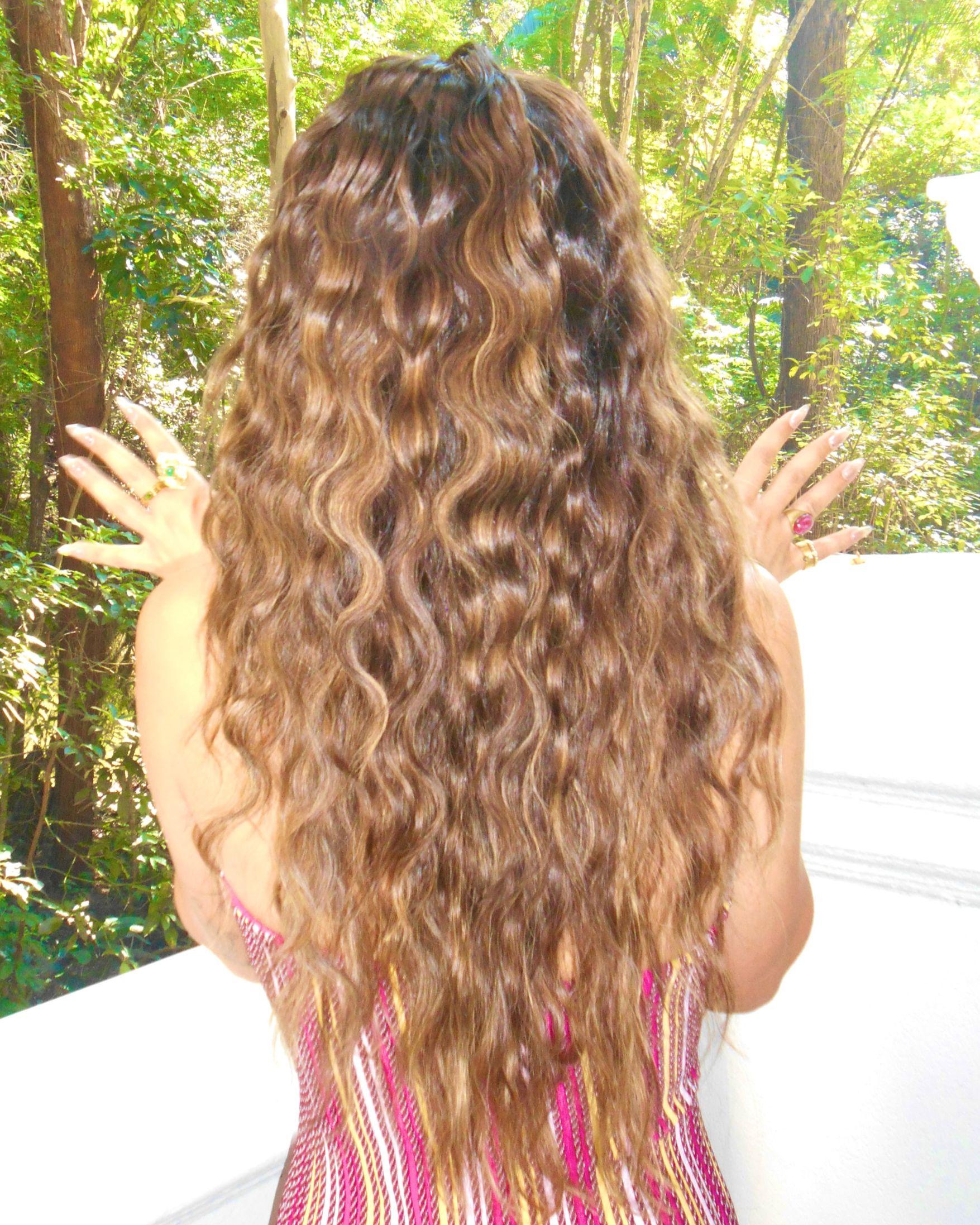 Back view of Mika Abdalla's layered shag haircut with long textured waves and crown layering from the Off Campus press tour.