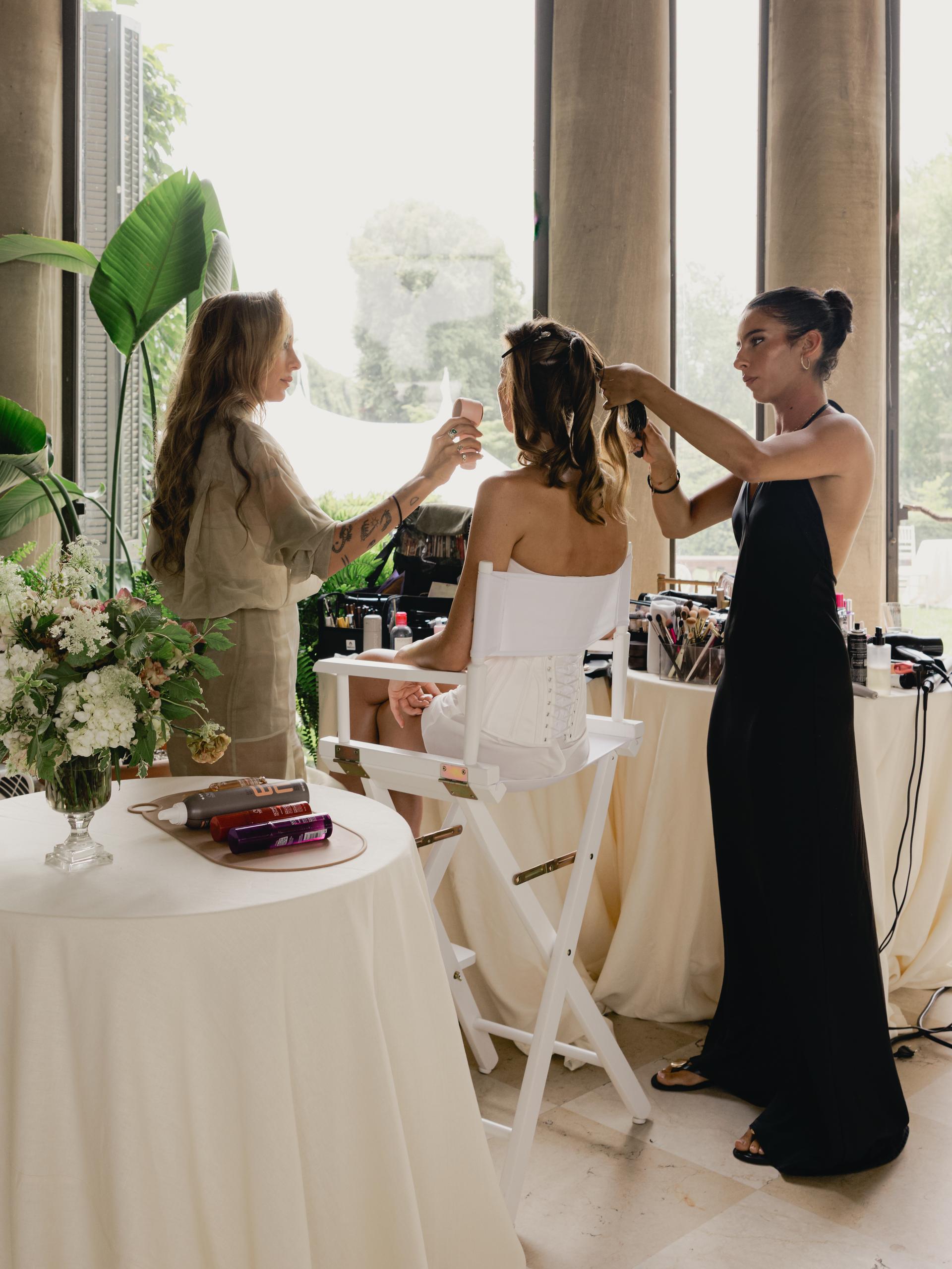 Behind the scenes as Paige Lorenze's soft brunette highlights are styled into a sleek bridal updo on her wedding day.