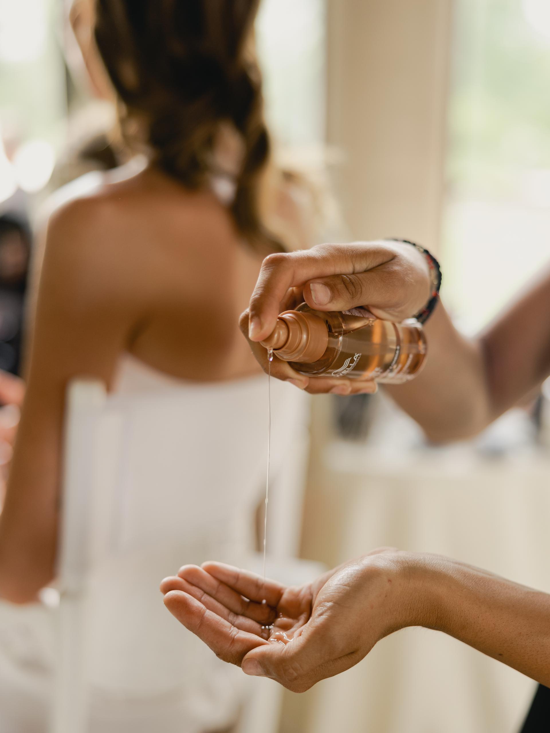 Wella Professionals Ultimate Smooth Miracle Oil Serum being applied during the finishing touches of Paige Lorenze's wedding hairstyle.