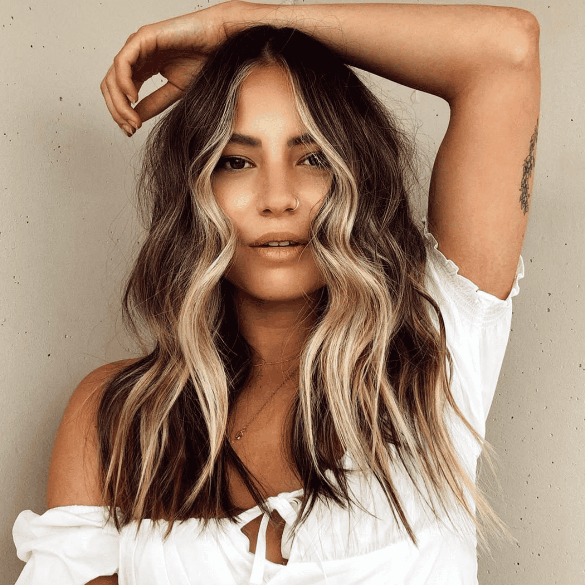 brunette with soft waves and money piece medium length hair