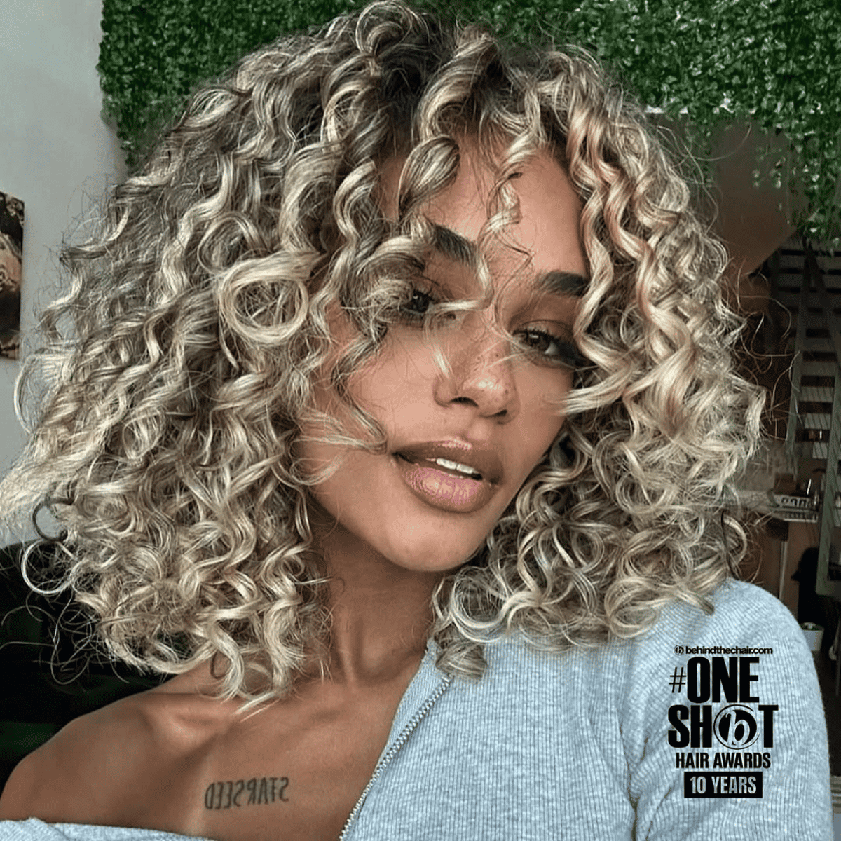 Soft blonde curls on a model wearing a grey top.