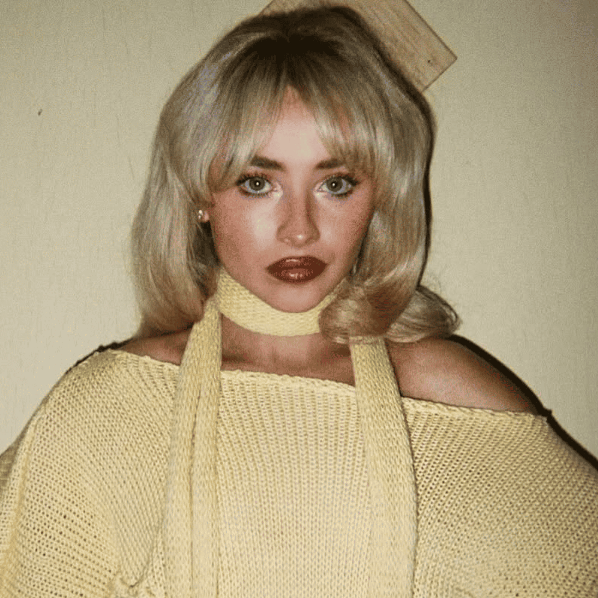 Sabrina Carpenter with voluminous buttery blonde curls and fringe, styled with retro flair in “Manchild.”