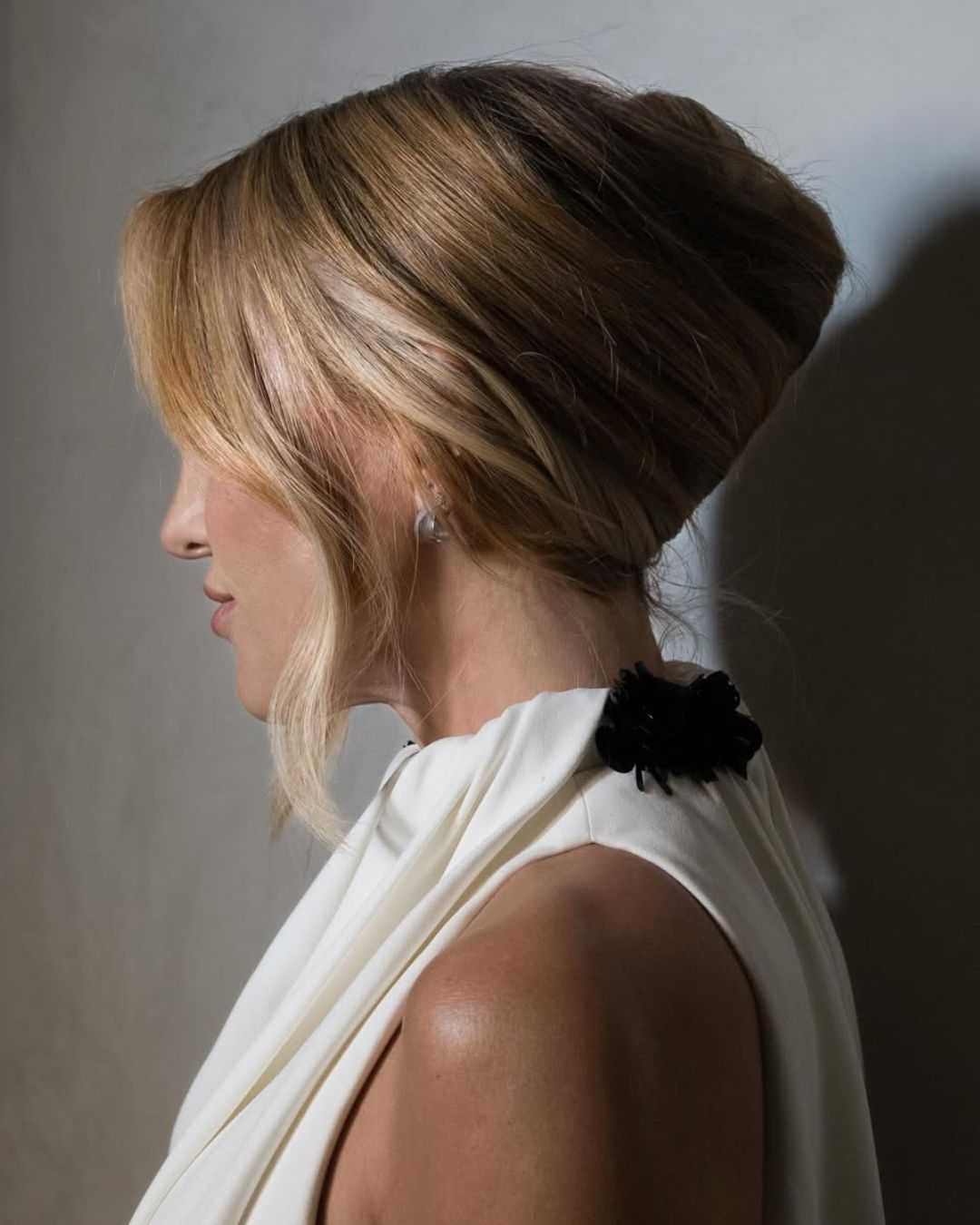Front view of Kate Hudson’s soft glam look with a loose French twist and center-parted face-framing layers