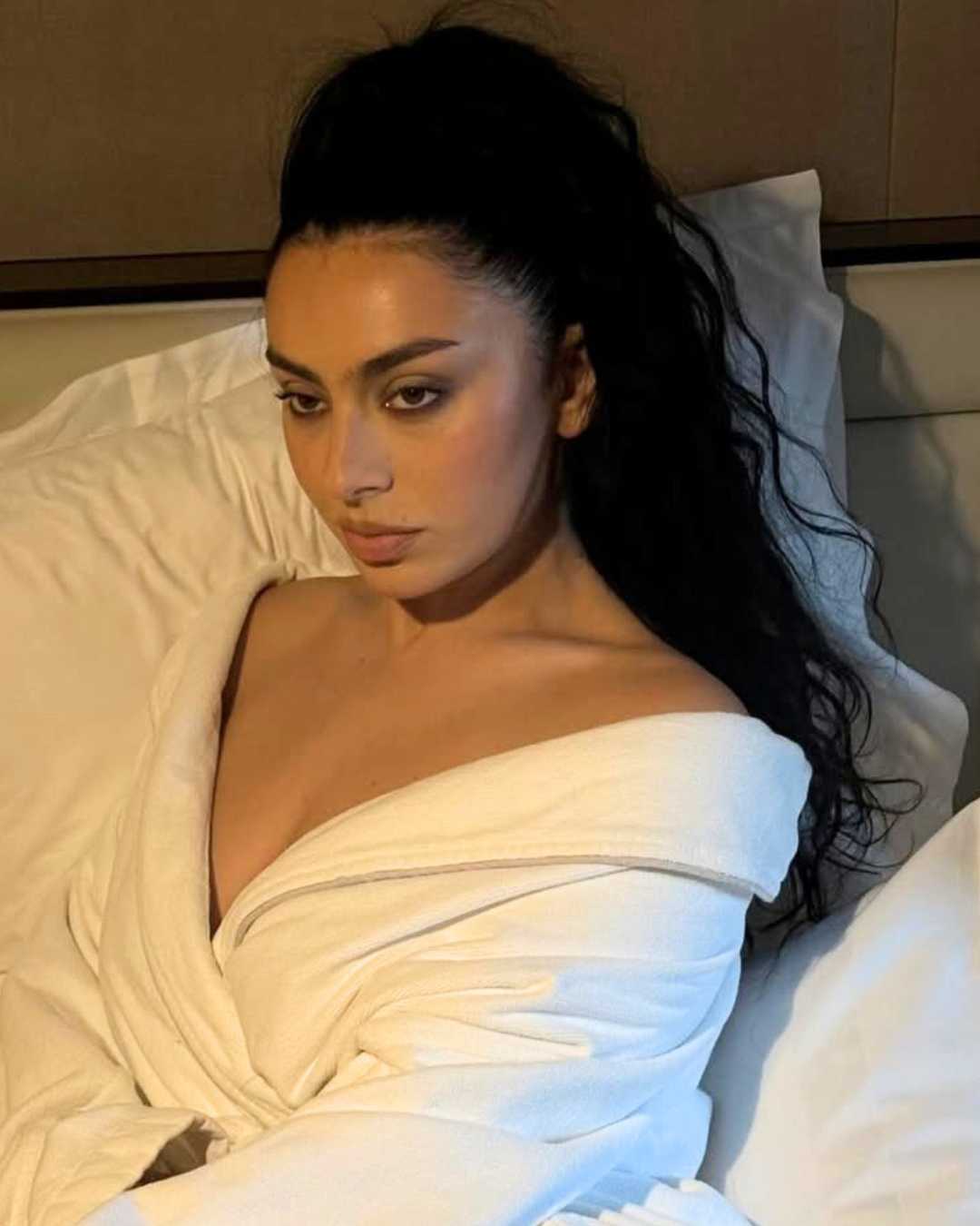 Charli XCX in a white robe glossy black hair side view Photo Credit Instagram via @mattbens