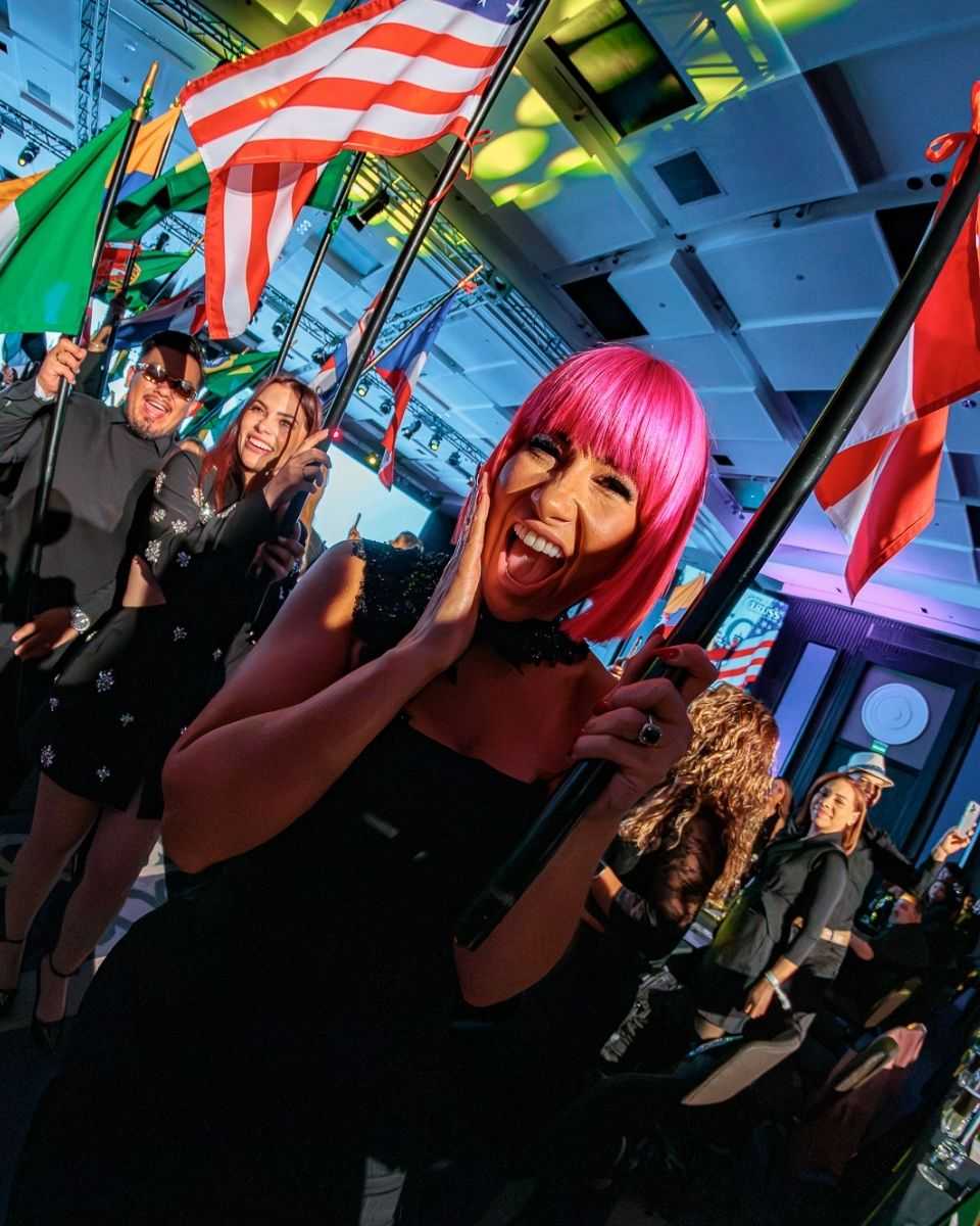 TRUSS Global Ambassador Lisa Hernandez carries a flag during the opening ceremony celebrating the event's international community.