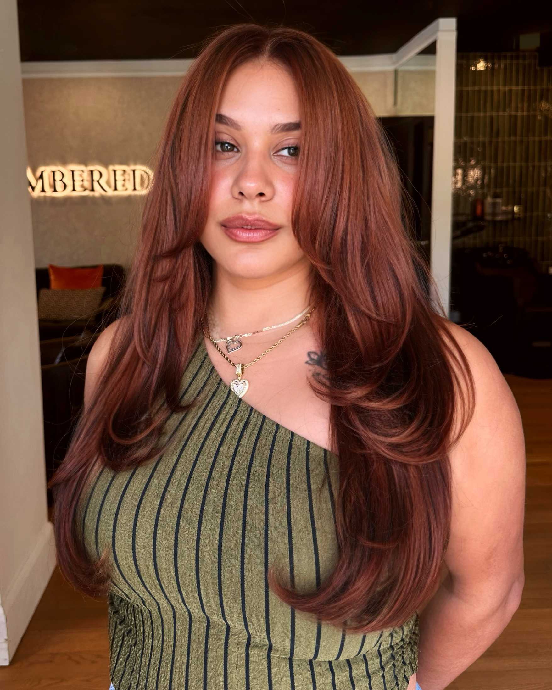 Long layered copper brunette hair with soft dimension, glossy shine and face-framing layers created with Redken Shades ALK.