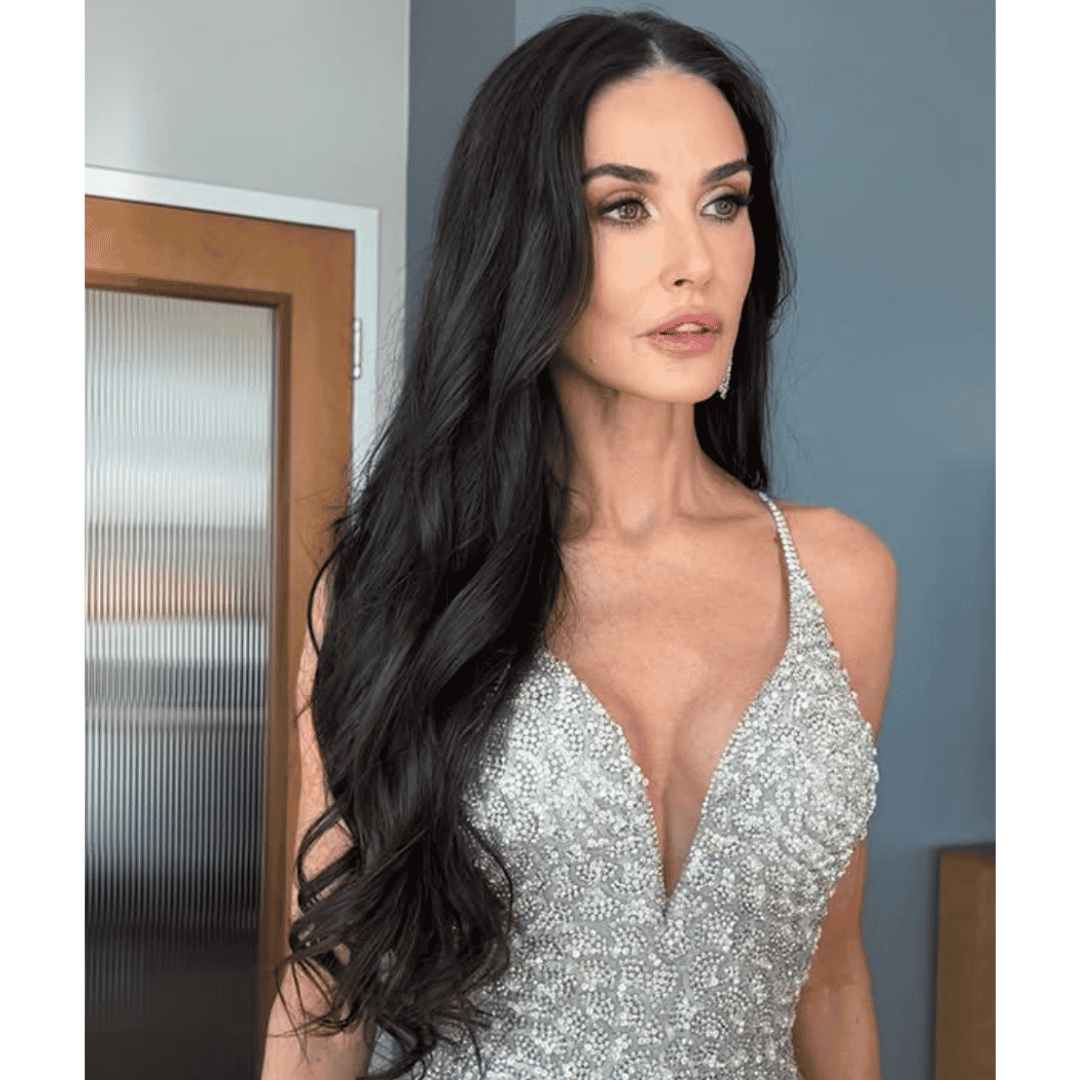 Demi Moore ready for the 2025 Oscars with long, loose waves, wearing a silver gown with a deep V-neckline