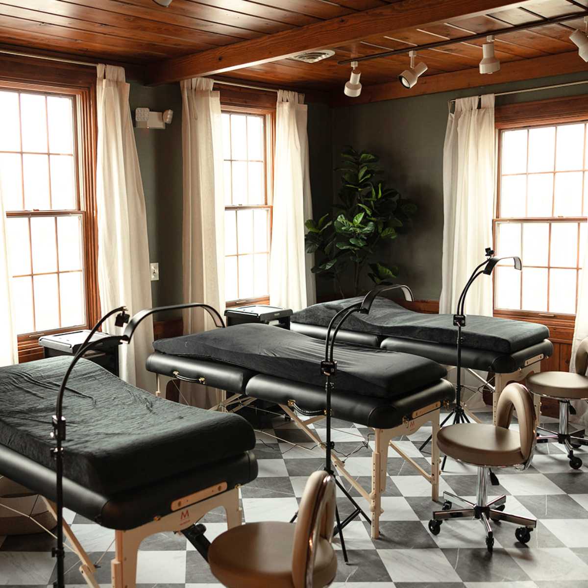 furnished spa with black tables and wood ceiling/windows