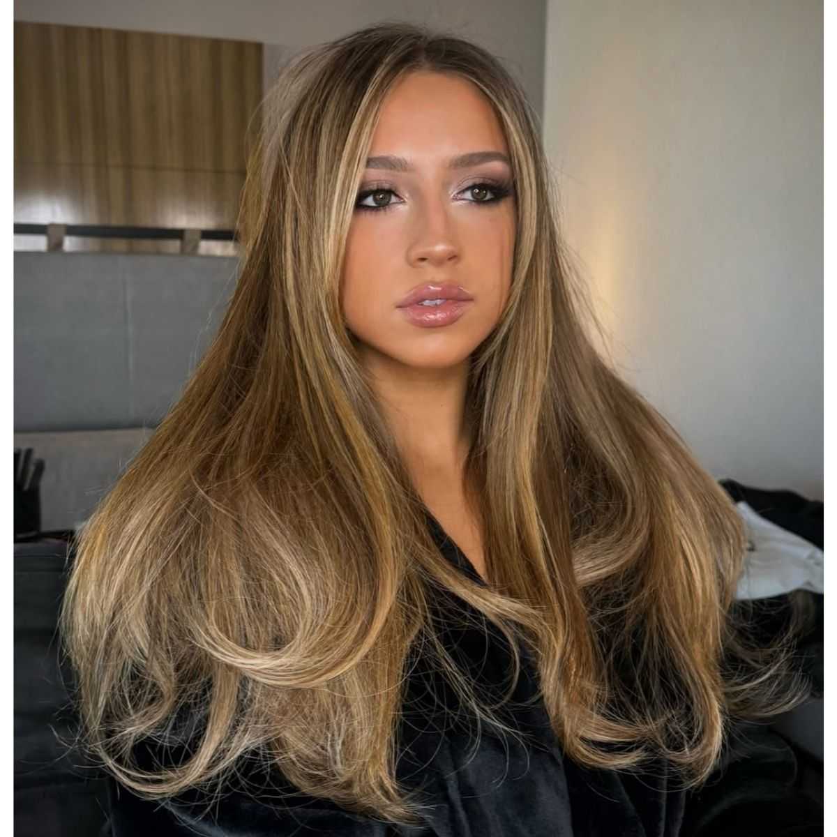 Tate McRae with long, honey-blonde hair styled in smooth, blended layers with face-framing volume.