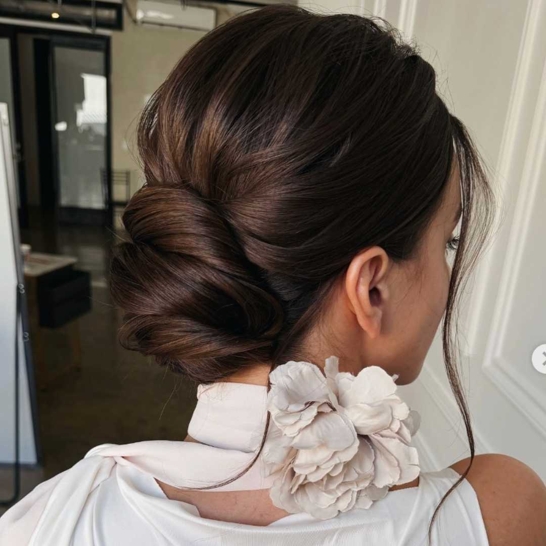 Soft, low chignon hairstyle with loose face-framing pieces and natural texture