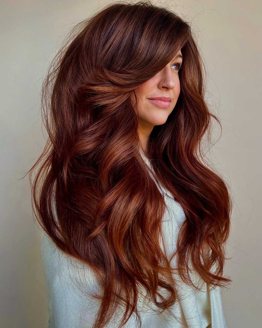 Long modern auburn hair with curtain fringe, soft layers and copper-red dimension