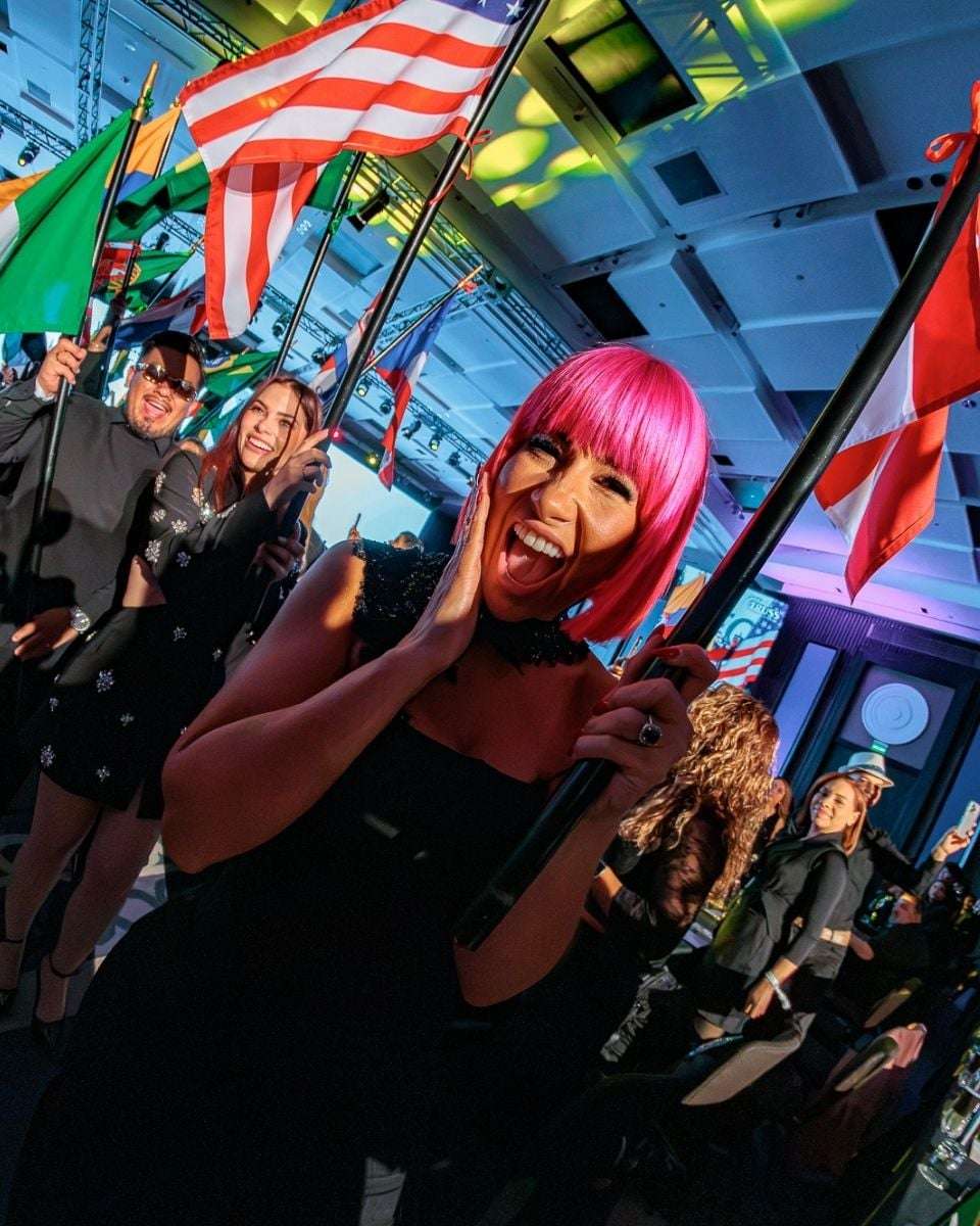 TRUSS Global Ambassador Lisa Hernandez carries a flag during the opening ceremony celebrating the event's international community.