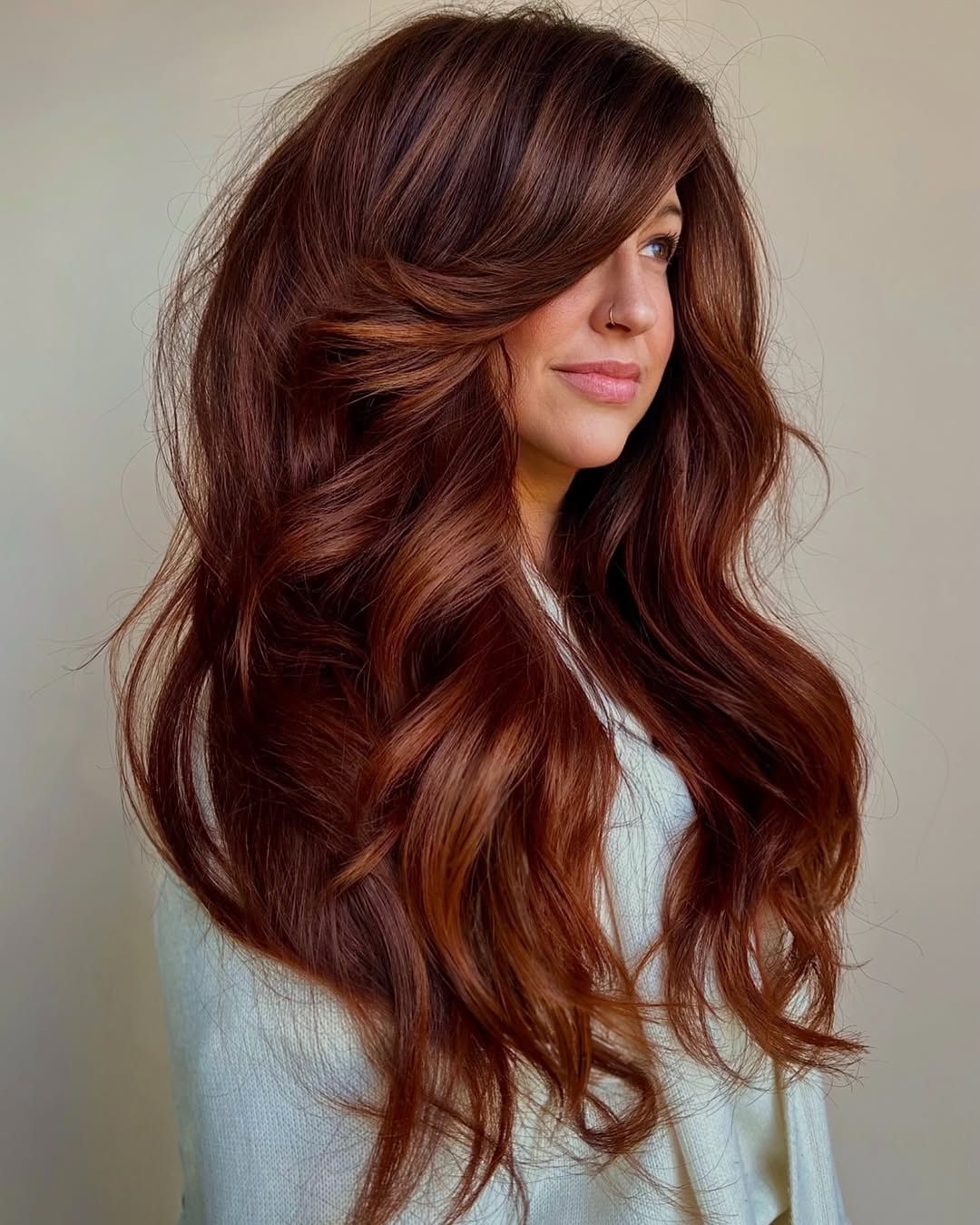 Long modern auburn hair with curtain fringe, soft layers and copper-red dimension