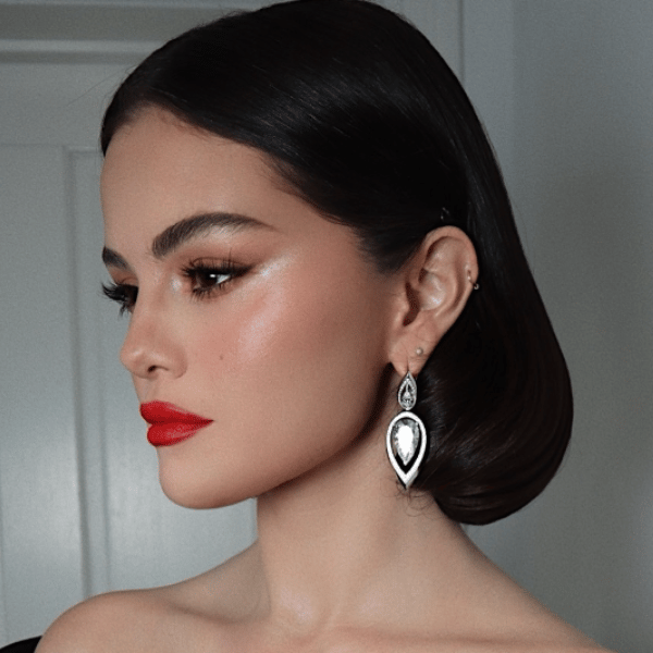 Selena Gomez at the 2025 SAG Awards with sleek, 1960s-inspired hair, styled by Renato Campora, featuring a deep side tuck.