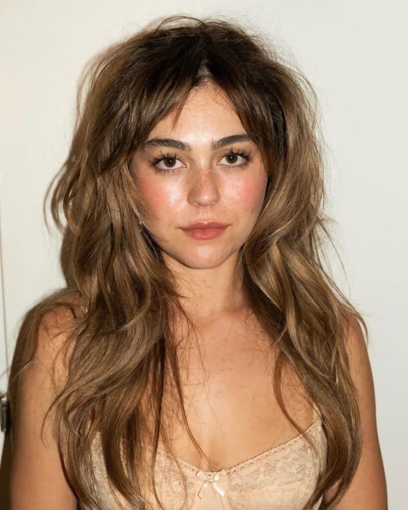Actress Mika Abdalla wearing Allie Hayes' heavily layered shag haircut with full fringe from the Off Campus press tour.